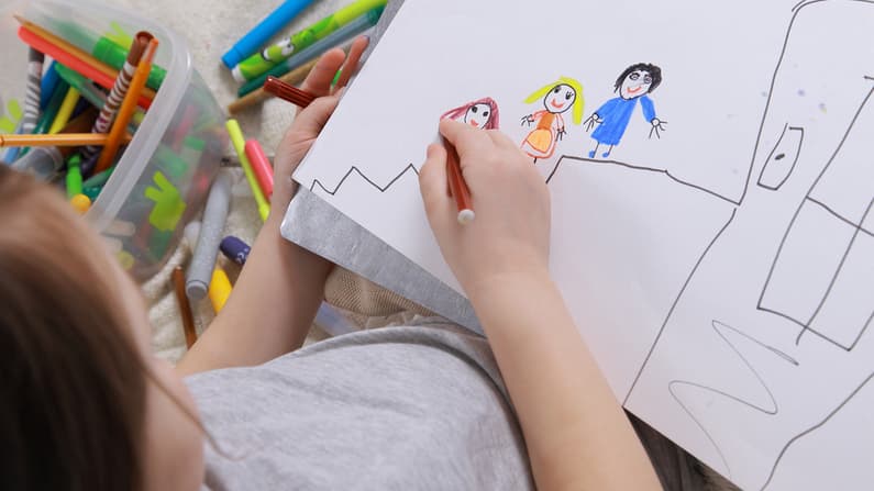 Girl drawing her family in an art therapy session