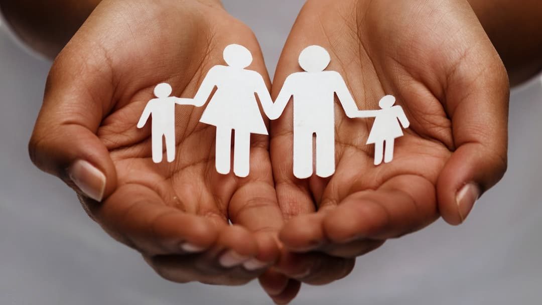 mother's hands holding a paper cut out family