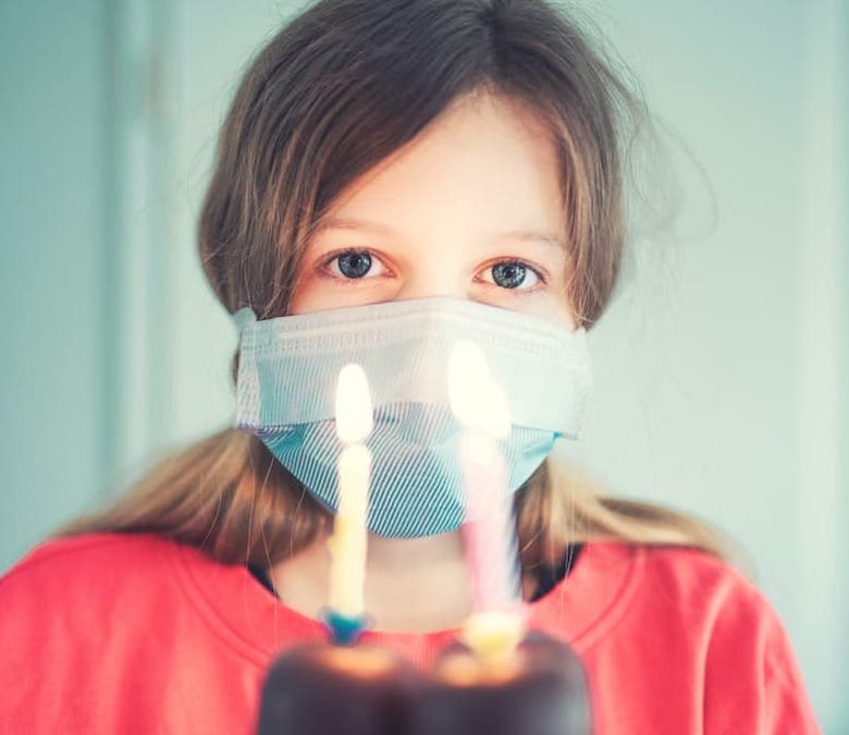 Child celebrating a birthday wearing a Coronavirus mask